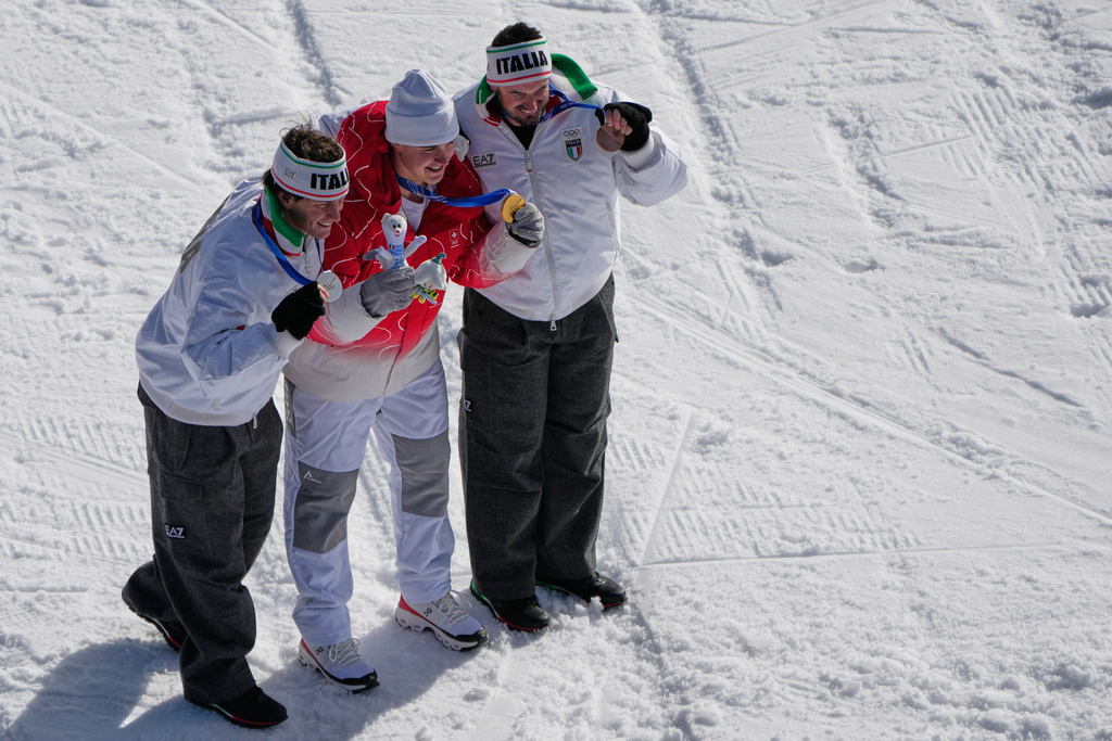 Switzerland's Franjo von Allmen, center, gold, Italy's Giovanni Franzoni, left, silver, and Italy's Dominik Paris, bronze, pose after an alpine ski, men's downhill race, at the 2026 Winter Olympics, in Bormio, Italy, Saturday, Feb. 7, 2026. (AP Photo/John Locher)