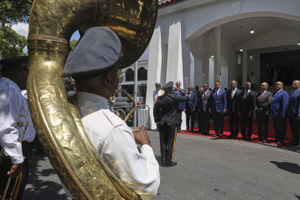 Transitional presidential council members listen to Haiti's national anthem during the installation ceremony of Laurent Saint-Cyr as the new president of the council in Port-au-Prince, Haiti, Thursday, Aug. 7, 2025. (AP Photo/Odelyn Joseph)
