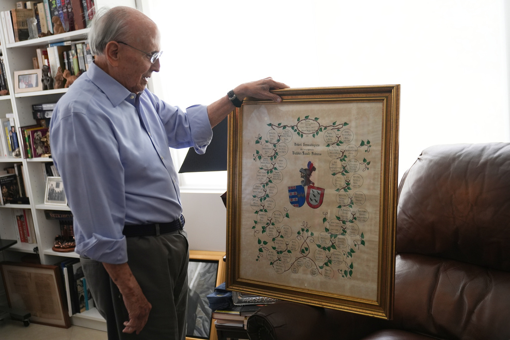Raul Valdes-Fauli holds a genealogical chart showing his family's history in Cuba dating back to colonial times Tuesday, April 21, 2026, in Coral Gables, Fla. (AP Photo/Marta Lavandier)