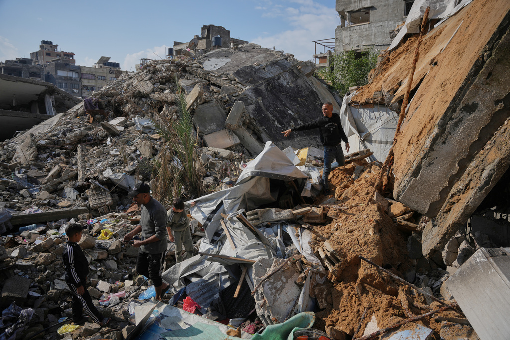 Members of the Al-Hosari family check the rubble looking for their belongings after their house collapsed, killing, according to Al-Shafa Hospital officials, at least one person and leaving several others injured in Gaza City, Tuesday, Dec. 16, 2025. (AP Photo/Abdel Kareem Hana)