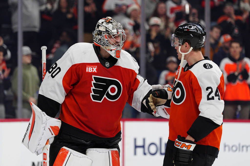 Philadelphia Flyers goaltender Dan Vladar, left, celebrates with Nick Seeler after a victory in an NHL hockey game against the Vancouver Canucks, Monday, Dec. 22, 2025, in Philadelphia. (AP Photo/Derik Hamilton)