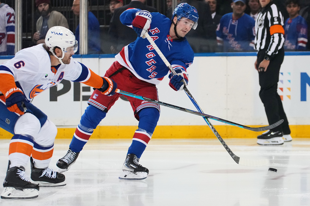 New York Rangers' Alexis Lafreni&egrave;re, right, shoots the puck past New York Islanders' Ryan Pulock (6) for a goal during the second period of an NHL hockey game Tuesday, Oct. 6, 2026, in New York. (AP Photo/Frank Franklin II)