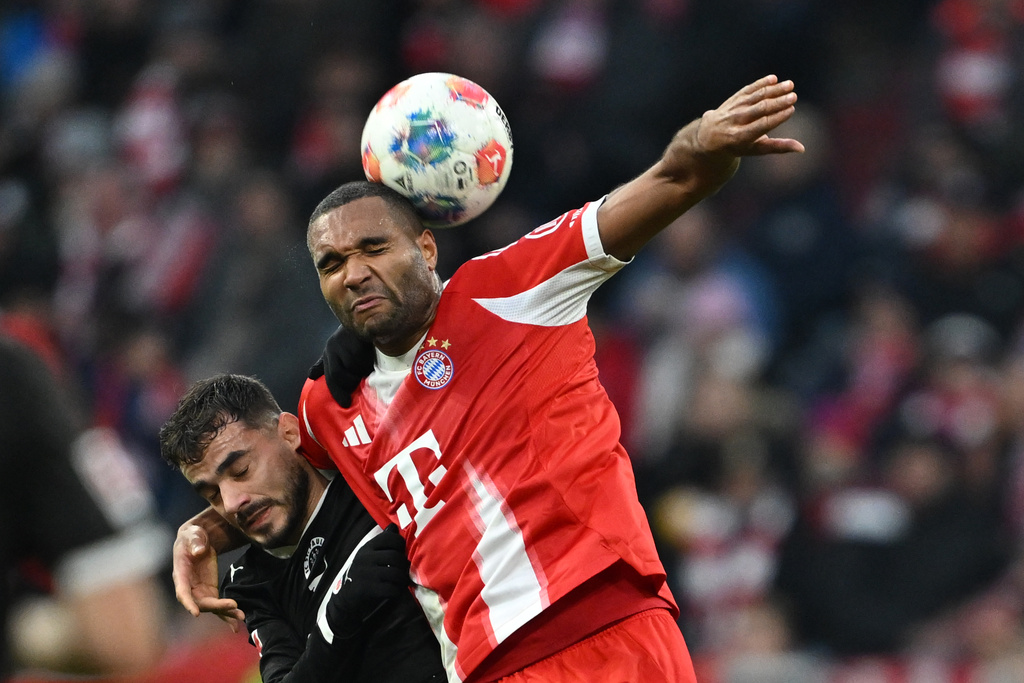 Bayern Munich's Jonathan Tah and St. Pauli's Danel Sinani, left, in action during the Bundesliga soccer match between Bayern Munich and FC St. Pauli in Munich, Germany, Saturday Nov. 29, 2025. (Sven Hoppe/dpa via AP)