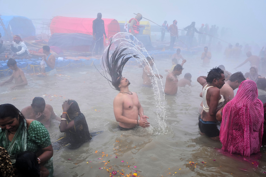 Devotees take a holy dip on Mauni Amavasya, a divine occasion in Hindu religious practice followed for honoring ancestors or forefathers, at the Sangam, the confluence of the Ganges, the Yamuna and the mythical Saraswati rivers, during the annual month long Hindu religious fair "Magh Mela" in Prayagraj, India, Sunday, Jan.18, 2026. (AP Photo/Rajesh Kumar Singh)