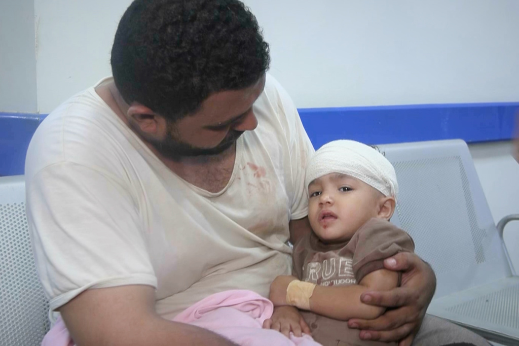 This image taken from video released by Al-Masirah TV, a channel owned by Yemen's Houthi rebels, on Tuesday, Sept. 22, 2026, shows a man at a hospital holding a child who, according to the channel, was wounded in a Saudi airstrike on a house in Mokha, Taiz province, Yemen. (Al-Masirah TV via AP)