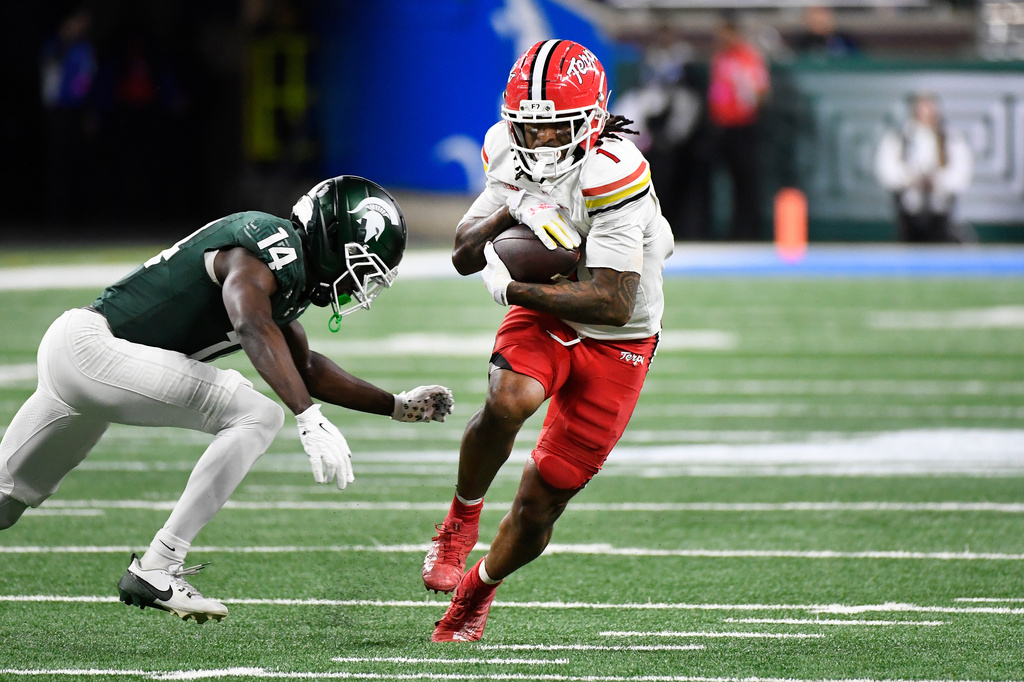 Maryland wide receiver Jalil Farooq, right, runs with the ball as he is chased by Michigan State defensive back Malcolm Bell during the first half of an NCAA college football game, Saturday, Nov. 29, 2025, in Detroit. (AP Photo/Jose Juarez)
