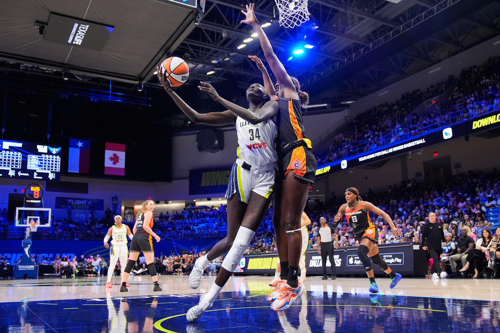 Dallas Wings forward Awak Kuier (34) shoots as Connecticut Sun's Diamond Miller, right, defends in the first half of a WNBA basketball game Sunday, Aug. 30, 2026, in Arlington, Texas. (AP Photo/Tony Gutierrez)