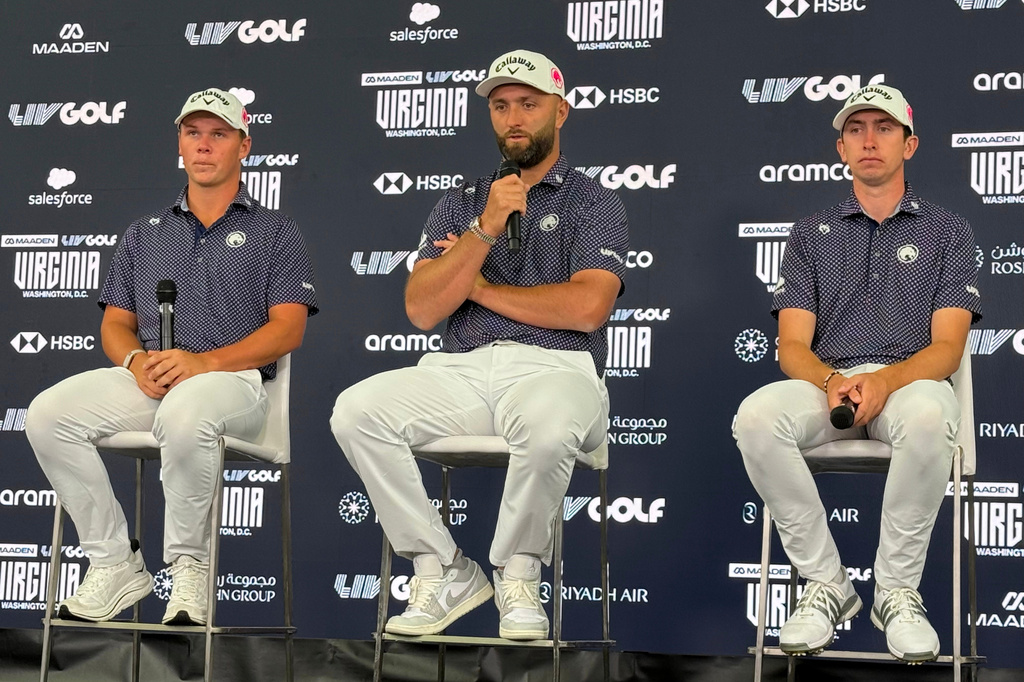 Jon Rahm, flanked by teammates Caleb Surratt, left, and Tom McKibbin, right, takes questions during a LIV Golf news conference in Sterling, Va., Tuesday, May 5, 2026. (AP Photo/Ben Nuckols)
