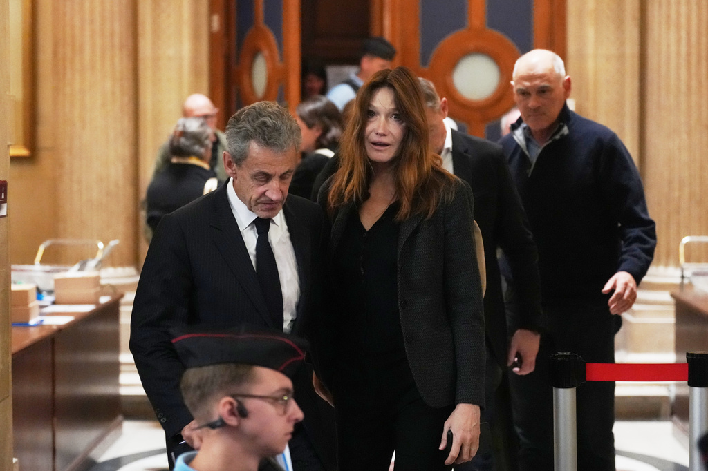 Former French President Nicolas Sarkozy and his wife Carla Bruni-Sarkozy leave the appeals courthouse in Paris, France, Tuesday, April 7, 2026, during his trial appealing a conviction involving illegal campaign funds from Libya. (AP Photo/Thibault Camus)