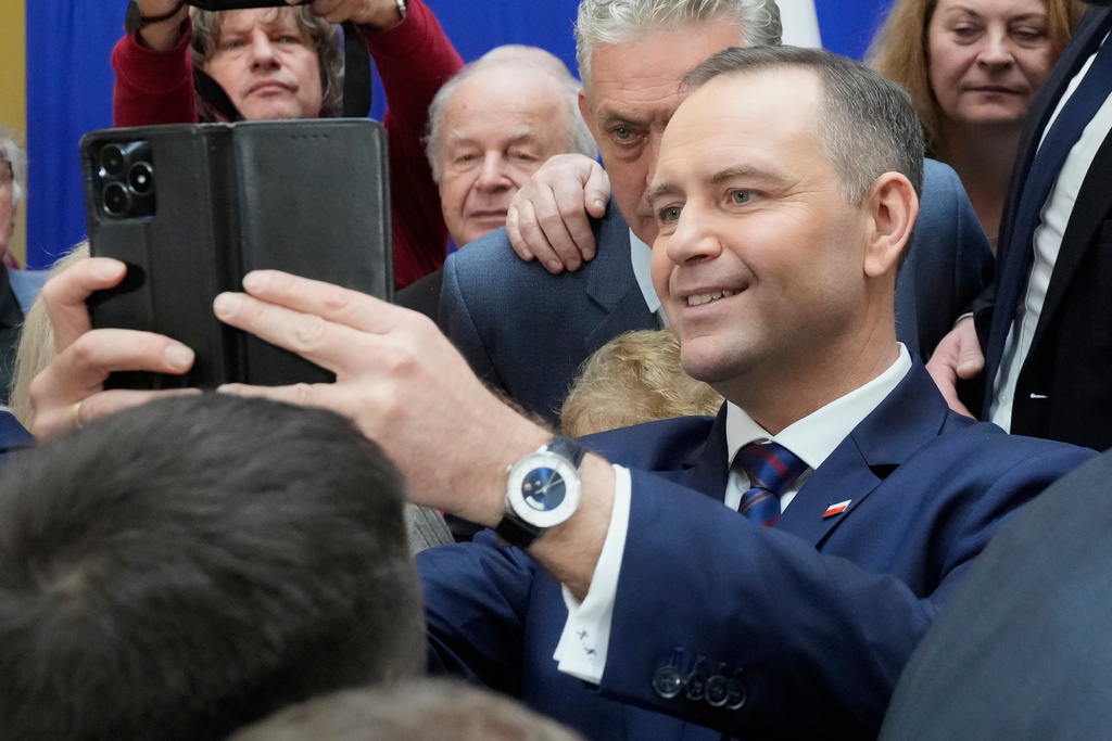 Polish President Karol Nawrocki meets senior citizens and signs a draft law to their benefit during a visit to the public library in Sochaczew, near Warsaw, Poland, Monday, Nov. 3, 2025. (AP Photo/Czarek Sokolowski)