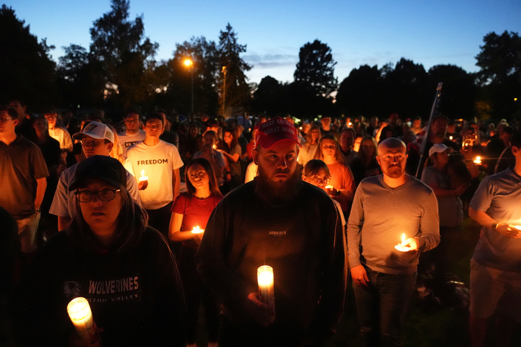FILE - Carly Jenkins, left, and Alex Thomson, center, pay their respects alongside others during a vigil for Charlie Kirk on Sept. 12, 2025, in Provo, Utah. (AP Photo/Lindsey Wasson, File)