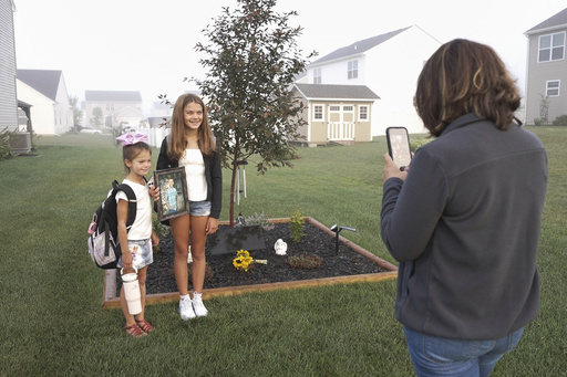 Ashlee Dahlberg takes photos of her daughters Ava, left, and Khloe, on the first day of school in front a memorial for their brother, Liam, in their yard in Lowell, Ind., on Wednesday, Aug. 13, 2025. (AP Photo/Laura Bargfeld) Ashlee Dahlberg takes photos of her daughters Ava, left, and Khloe, on the first day of school in front a memorial for their brother, Liam, in their yard in Lowell, Ind., on Wednesday, Aug. 13, 2025. (AP Photo/Laura Bargfeld)