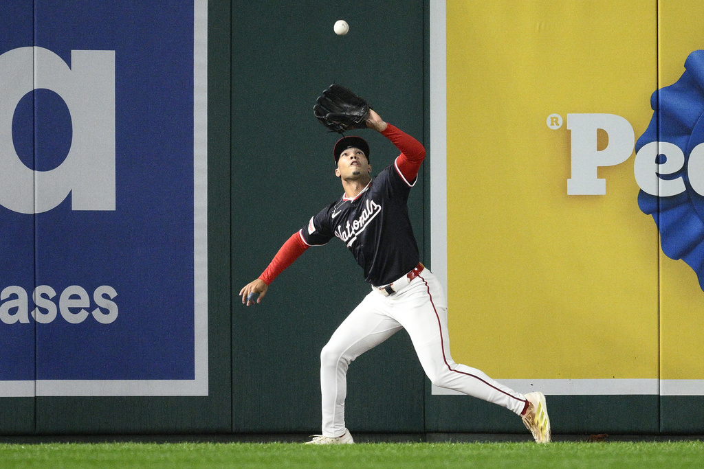 Washington Nationals left fielder Daylen Lile (51) makes a catch for the out on a fly ball by Atlanta Braves' Matt Olson during the first inning of the second baseball game of a doubleheader, Tuesday, Sept. 16, 2025, in Washington. (AP Photo/Nick Wass)
