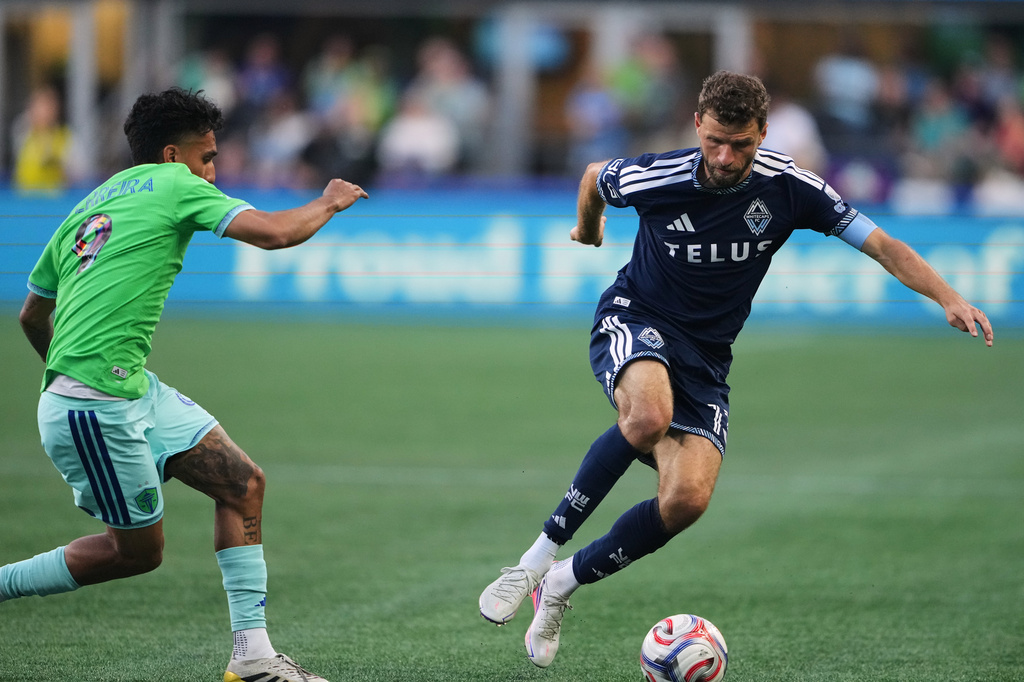 Vancouver Whitecaps forward Thomas Müller, right, moves the ball against Seattle Sounders forward Jesús Ferreira (9) during the first half of an MLS soccer match, Sunday, Aug. 16, 2026, in Seattle. (AP Photo/Lindsey Wasson)