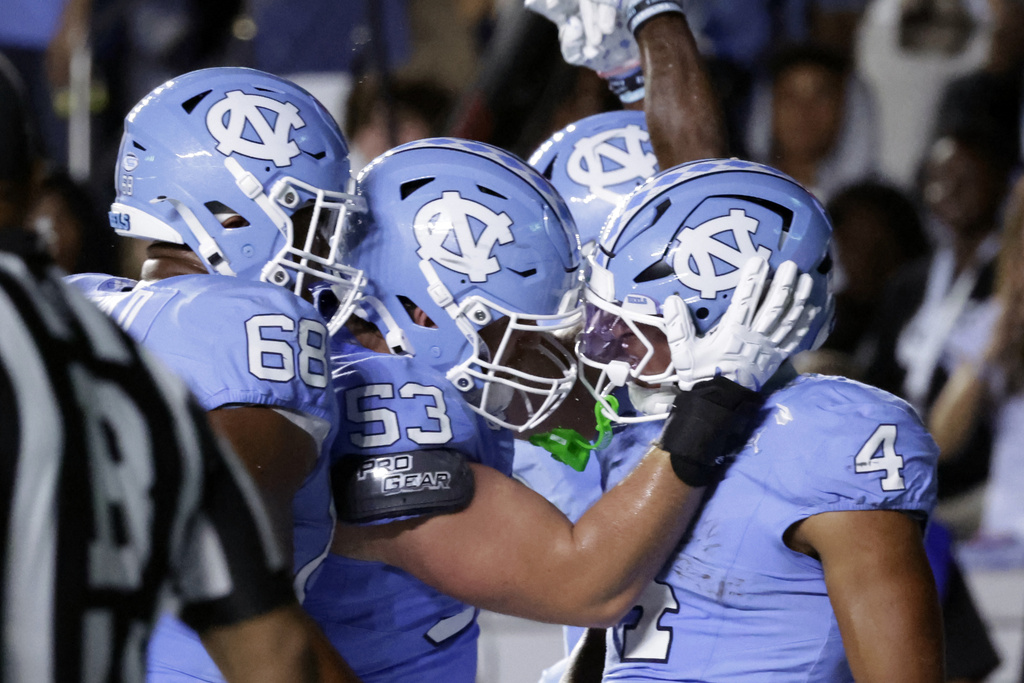 North Carolina running back Caleb Hood (4) celebrates after his touchdown with offensive linemen Aidan Banfield (68) and Christo Kelly (53) during the first half of an NCAA college football game against TCU, Monday, Sept. 1, 2025, in Chapel Hill, N.C. (AP Photo/Chris Seward)