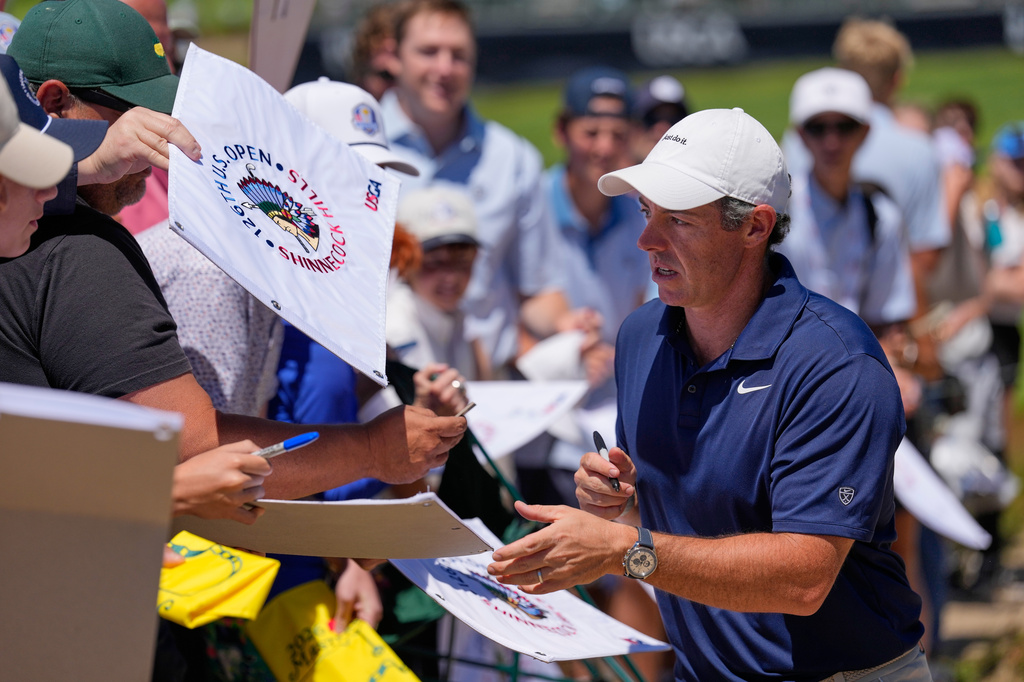 Rory McIlroy, of Northern Ireland, signs autographs during a practice round for the U.S. Open golf tournament at Shinnecock Hills Golf Club in Southampton, N.Y., Monday, June 15, 2026.(AP Photo/David J. Phillip)