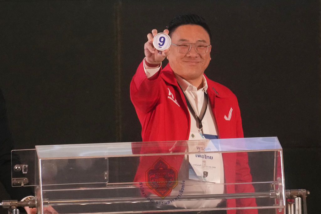 Pheu Thai Party's Julapun Amornviva shows his number after a drawing at a candidate registration in Bangkok, Thailand, Sunday, Dec. 28, 2025. (AP Photo/Sakchai Lalit)