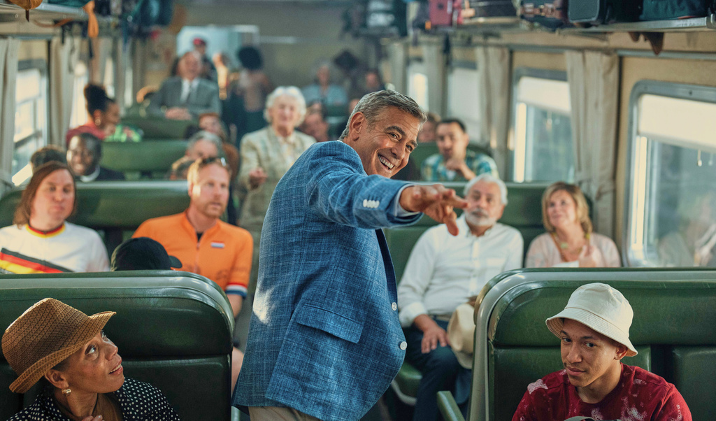 This image released by Netflix shows George Clooney, center, in a scene from "Jay Kelly." (Peter Mountain/Netflix via AP)