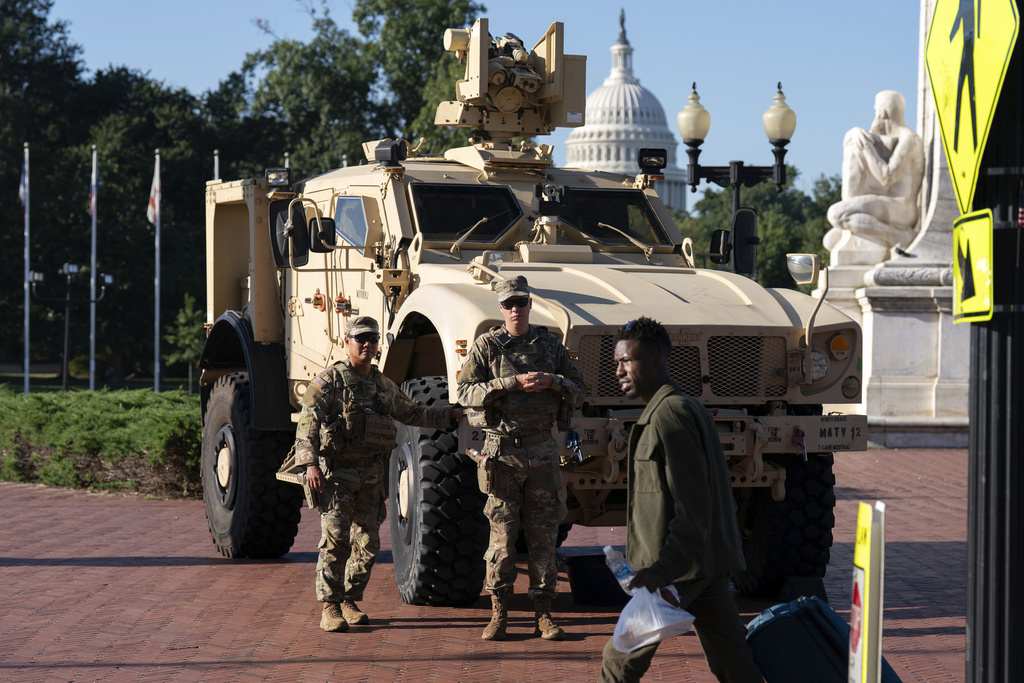Members of the District of Columbia National Guard standing next to an MATV vehicle scan the area as they patrol outside Union Station, Monday, Sept. 1, 2025, in Washington. (AP Photo/Jose Luis Magana)