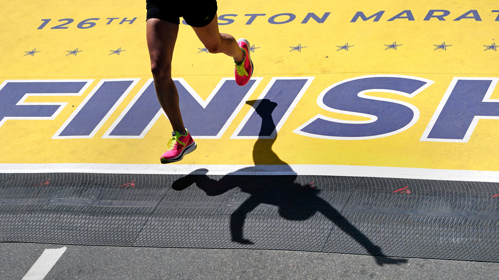 FILE - A runner crosses the finish line of the Boston Marathon, April 18, 2022, in Boston. (AP Photo/Charles Krupa, File)