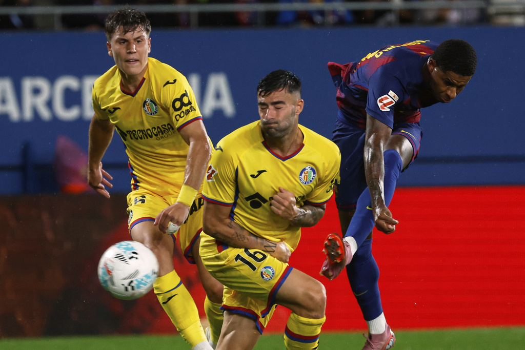 Barcelona's Marcus Rashford kicks the ball next to Getafe's Diego Rico during a Spanish La Liga soccer match between FC Barcelona and Getafe at the Johan Cruyff stadium in Barcelona, Spain, Sunday, Sept. 21, 2025. (AP Photo/Joan Monfort)