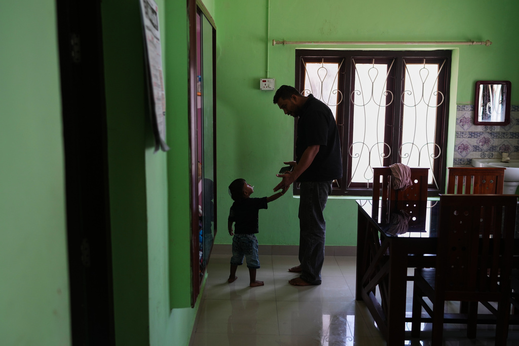 Safeer Mohammed Koorimannil plays with his nephew, Tahan Tabis, at their house in Sulthan Bathery in the southern state of Kerala, India, Thursday, March 12, 2026, after he said he paid more than $5,000 to be freed from a scam compound in Myanmar where he was trafficked. (AP Photo/Manish Swarup)