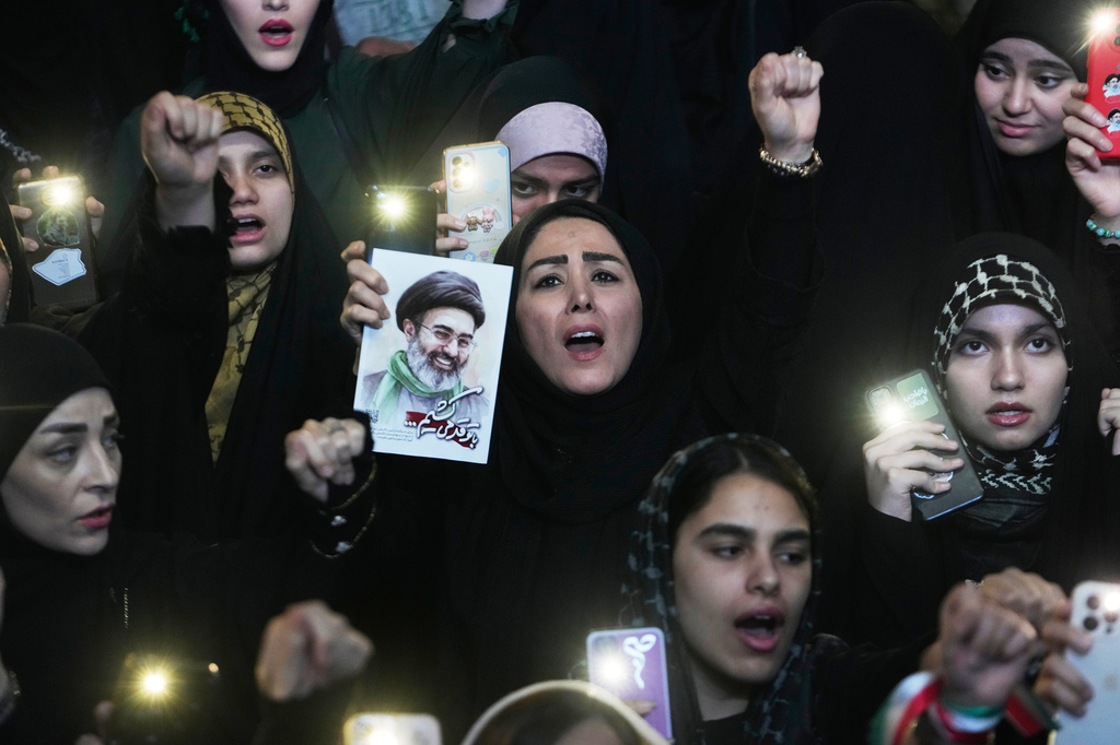 Pro-government demonstrators chant slogans as one of them holds a picture of the Iranian Supreme Leader Ayatollah Mojtaba Khamenei during their gathering at Enqelab-e-Eslami, or Islamic Revolution, square in Tehran, Iran, Monday, May 4, 2026. (AP Photo/Vahid Salemi)