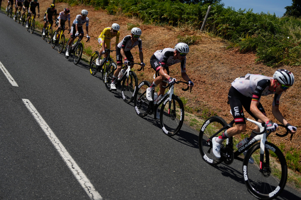 Slovenia's Tadej Pogacar, wearing the overall leader's yellow jersey, rides with the pack during the ninth stage of the Tour de France cycling race with start in Malemort and finish in Ussel, France, Sunday, July 12, 2026. (AP Photo/Mosa'ab Elshamy)