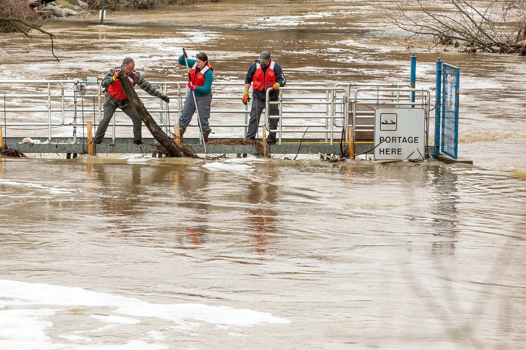 A team of assorted municipality workers clear debris from the Boardman River Weir that was blocking the flow of the flooded Boardman/Ottaway River on Wednesday, April 15, 2026, in downtown Traverse City, Mich. (Jan-Michael Stump/Traverse City Record-Eagle via AP)