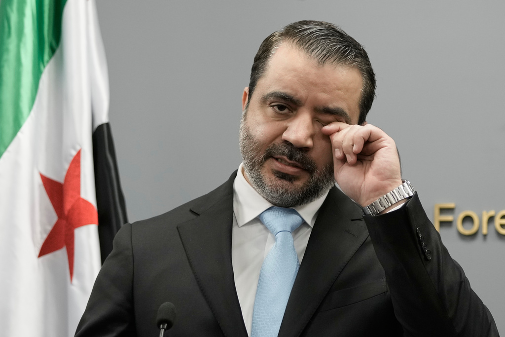 Syrian Foreign Minister Asaad al-Shibani wipes his eye as he speaks during a briefing for journalists following his meeting with Lebanese Foreign Minister Youssef Rajji, in Beirut, Lebanon, Friday, Oct. 10, 2025. (AP Photo/Hassan Ammar)