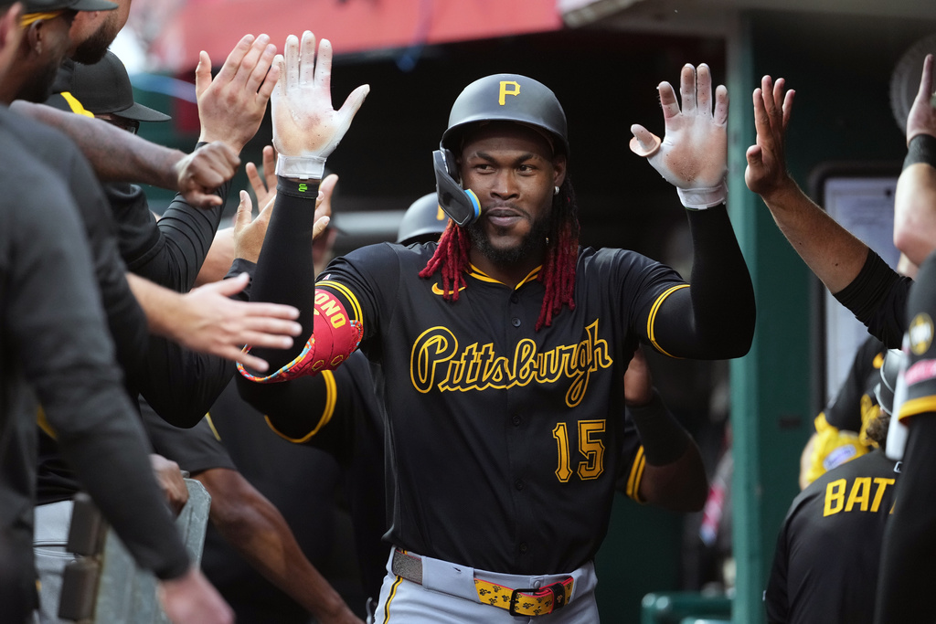 Pittsburgh Pirates' Oneil Cruz is congratulated in the dugout after hitting a two-run home run in the second inning of a baseball game against the Cincinnati Reds, Tuesday, Sept. 23, 2025, in Cincinnati. (AP Photo/Kareem Elgazzar)