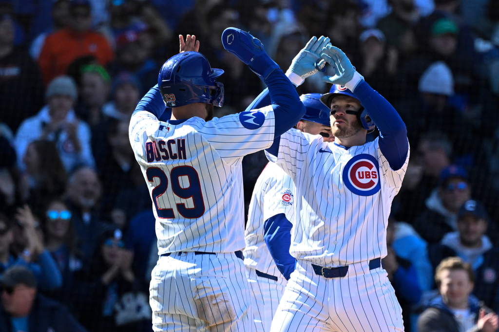 Chicago Cubs' Ian Happ, right, high-fives Michael Busch (29) after they score on Happ's three run home run during the sixth inning of a baseball game against the Washington Nationals, Saturday, March 28, 2026, in Chicago. (AP Photo/Matt Marton)
