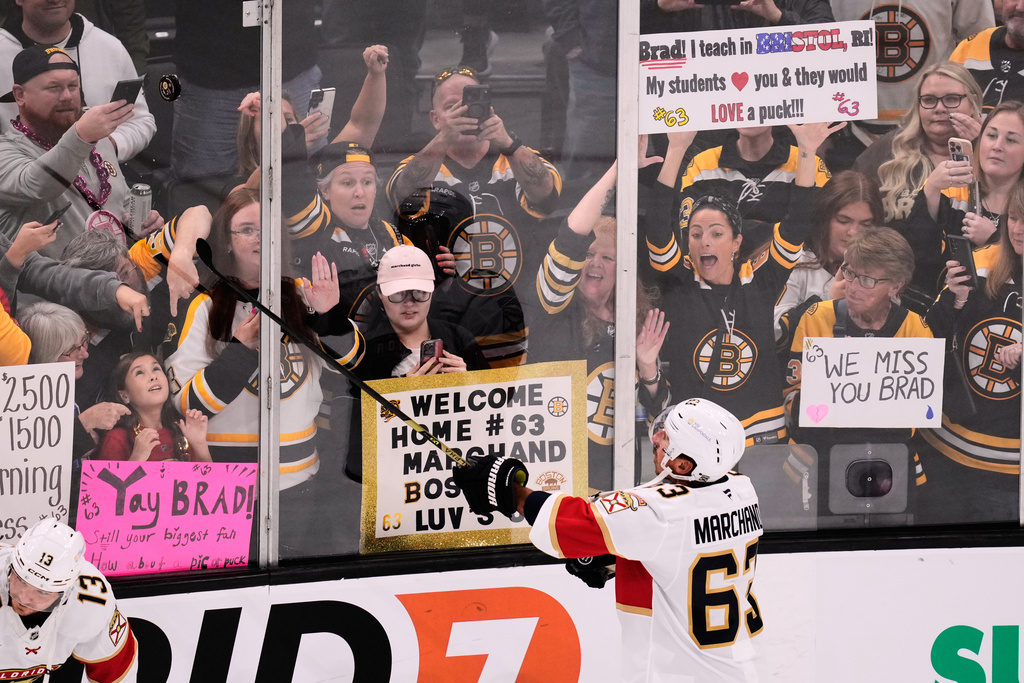 Florida Panthers left wing Brad Marchand (63) flips a puck to fans welcoming the former Boston Bruin back to Boston, where he played for more than 15 seasons, during a warm up prior to the first period of an NHL hockey game, Tuesday, Oct. 21, 2025, in Boston. (AP Photo/Charles Krupa)