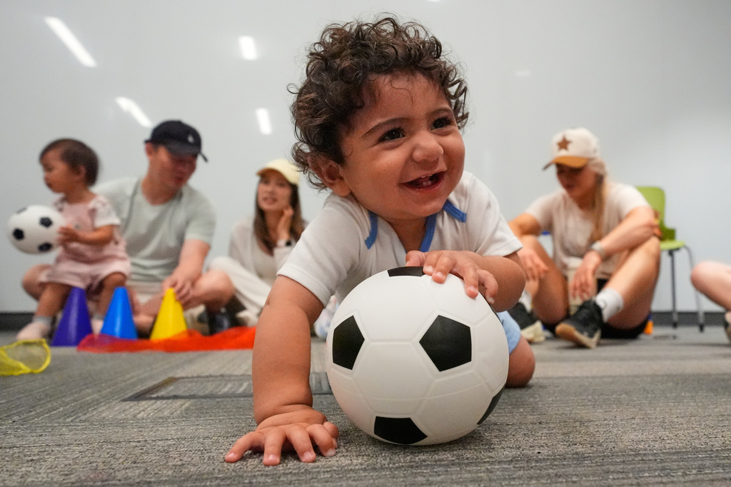 Ten-month-old Zain Fawaz plays with a soccer ball at a program introducing toddlers to the sport ahead of the World Cup soccer tournament Thursday, June 4, 2026, in Lenexa, Kan. (AP Photo/Charlie Riedel)