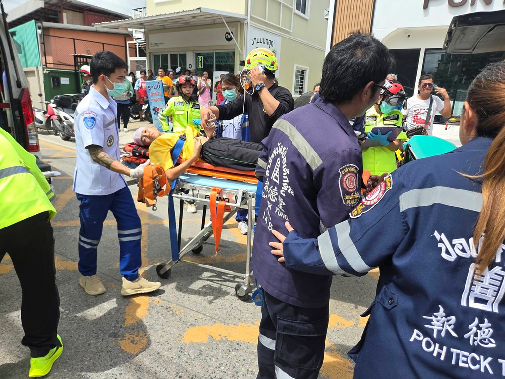 An injured is carried on a stretcher after a school shooting in Thailand's Nonthaburi province, Friday, Aug. 7, 2026. (Por Tek Tueng Nonthaburi via AP)