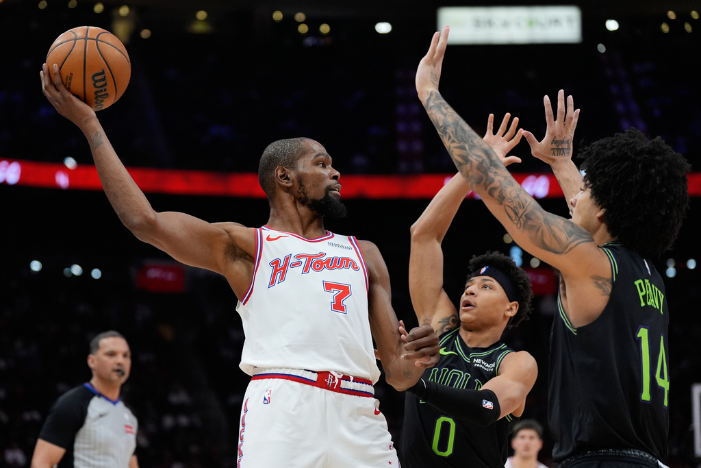 Houston Rockets forward Kevin Durant (7) looks to pass over New Orleans Pelicans guard Jeremiah Fears (0) and guard Micah Peavy (14) during the second half of an NBA basketball game in Houston, Sunday, Jan. 18, 2026. (AP Photo/Ashley Landis)