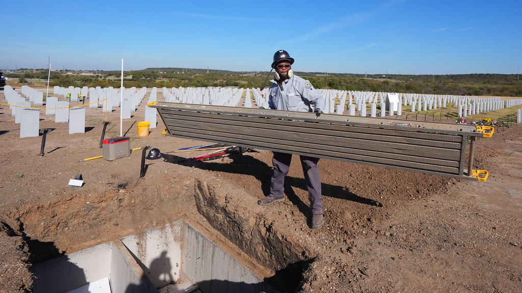 Unpaid federal worker and Navy veteran Mitchell Lankford prepares gravesites at the Dallas-Fort Worth National Cemetery in Dallas, Tuesday, Nov. 4, 2025. (AP Photo/LM Otero)