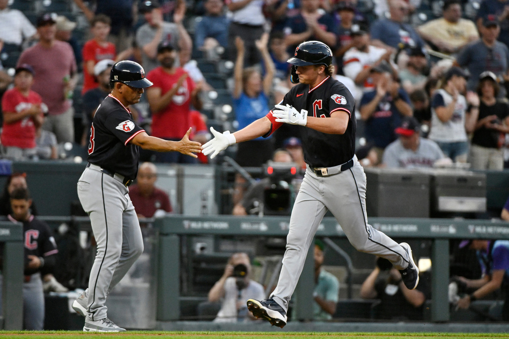 Cleveland Guardians third base coach Rouglas Odor, left, celebrates with Petey Halpin, right, as Halpin rounds the bases on a solo home run in the third inning of a baseball game against the Colorado Rockies, Friday, Aug. 21, 2026, in Denver. (AP Photo/Geneva Heffernan)