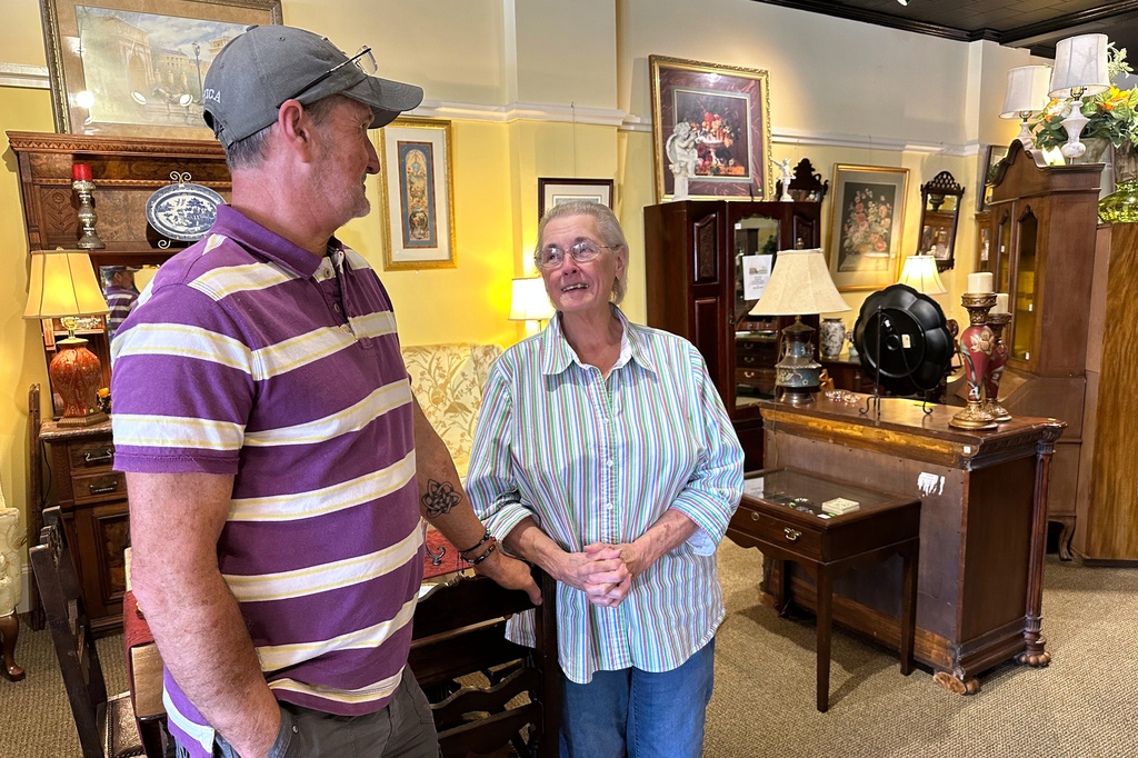 Michael Aycock, 56, left, and his mother Phyllis Aycock, 79, discuss economic conditions as they stand on the showroom floor of their antiques shop in downtown Nashville, N.C., March 11, 2026. (AP Photo/Bill Barrow)