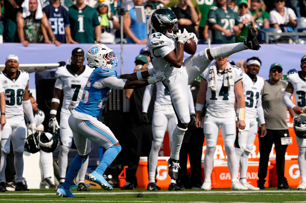 Philadelphia Eagles wide receiver Dontayvion Wicks (13) catches a pass over Tennessee Titans cornerback Marcus Harris (26) during the second half of an NFL football game, Sunday, Sept. 20, 2026, in Nashville, Tenn.(AP Photo/George Walker IV)