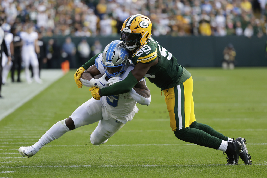 Detroit Lions running back David Montgomery (5) is brought down by Green Bay Packers linebacker Edgerrin Cooper (56) during the second half of an NFL football game Sunday, Sept. 7, 2025, in Green Bay, Wis. (AP Photo/Matt Ludtke)