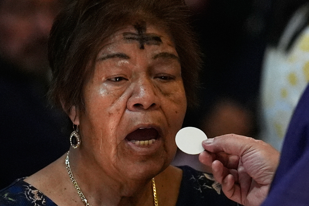 A parishioner takes communion on Ash Wednesday in Mexico City, Wednesday, Feb. 18, 2026. (AP Photo/Marco Ugarte)