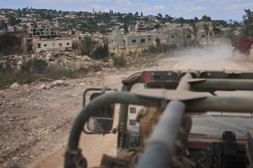 An Israeli soldier rides in a military vehicle past destroyed buildings in an area occupied by Israeli troops in southern Lebanon, Thursday, July 9, 2026. The Israeli military invited reporters on a tour of the strategic mountain topped by the Crusader-built Beaufort Castle months after launching a ground invasion that captured dozens of Lebanese villages and towns in southern Lebanon. (AP Photo/Ohad Zwigenberg)