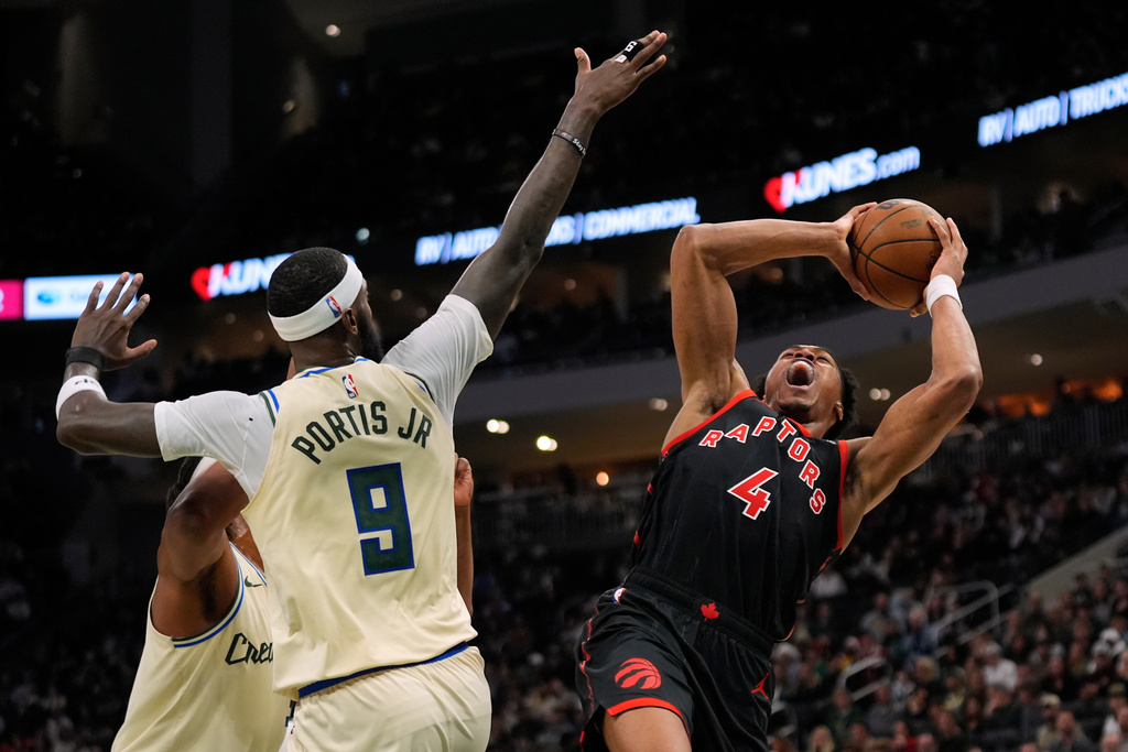 Toronto Raptors' Scottie Barnes (4) shoots against Milwaukee Bucks' Bobby Portis (9) during the first half of an NBA basketball game, Thursday, Dec. 18, 2025, in Milwaukee. (AP Photo/Aaron Gash)