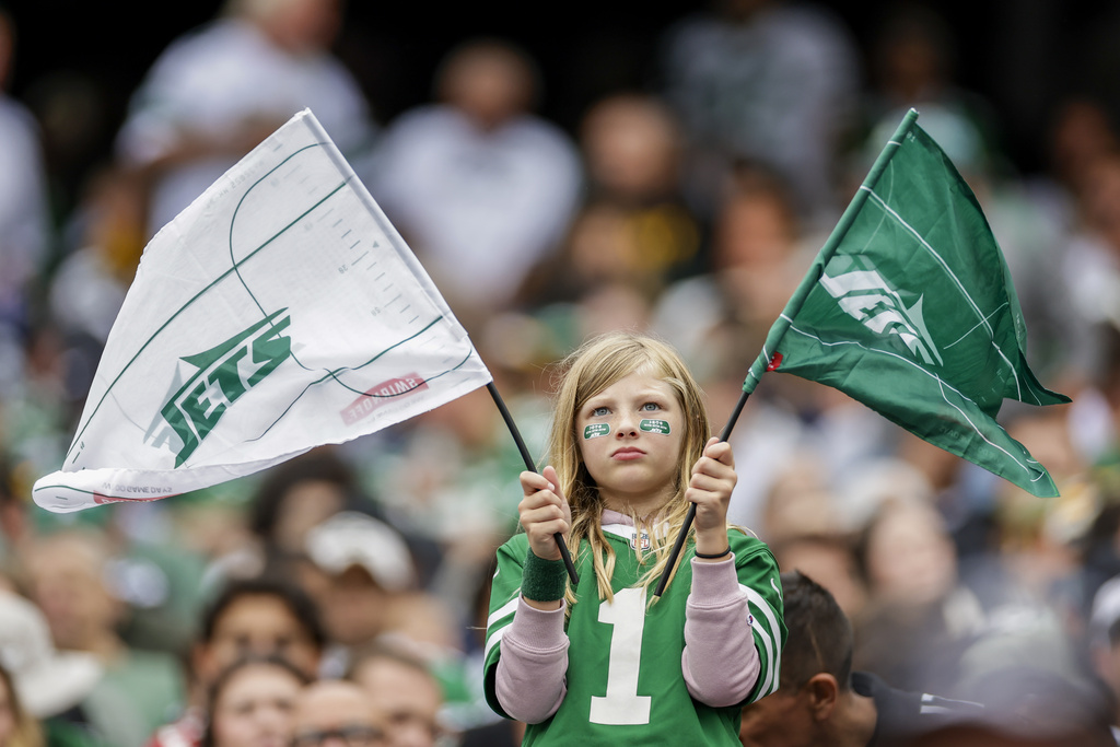 A spectator holds flags during the first half of an NFL football game between the New York Jets and the Pittsburgh Steelers Sunday, Sept. 7, 2025, in East Rutherford, N.J. (AP Photo/Adam Hunger)