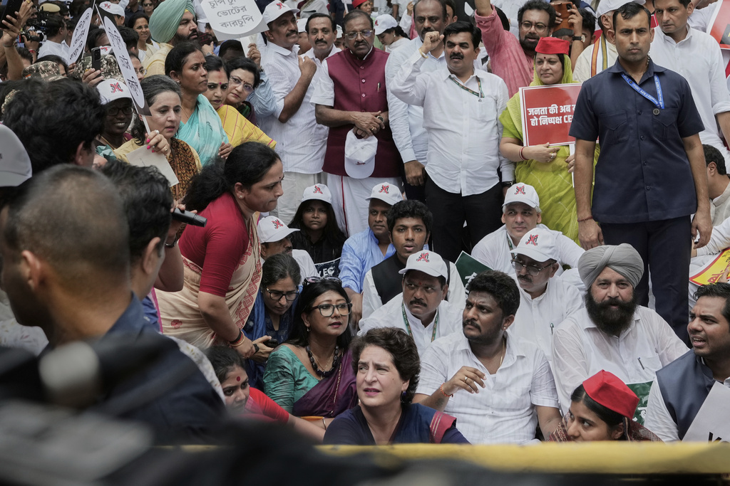 Congress party leader Priyanka Gandhi Vadra , center bottom, sits on the road with other parties lawmakers during a protest calling for the rollback of a controversial revision of the voter list in one of the country’s poorest states where key elections are scheduled in November, in New Delhi, India, Monday, Aug. 11, 2025. (AP Photo/Manish Swarup)