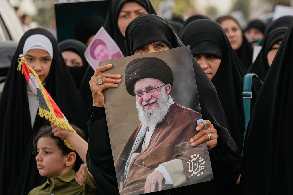 Iraqi women hold a portrait of Iran's late Supreme Leader Ayatollah Ali Khamenei and his son Ayatollah Mojtaba Khamenei, during a protest against U.S. and Israeli attacks on multiple cities across Iran, in the Shi'ite district of Kazimiyah in Baghdad, Iraq, Friday, April 3, 2026. (AP Photo/Hadi Mizban)