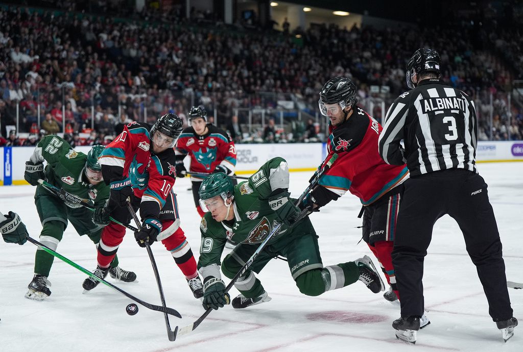 Kelowna Rockets' Tij Iginla (11) and Tomas Poletin (10) vie for the puck against Everett Silvertips' Zackary Shantz (19) and Jesse Heslop (22) during the second period of a Memorial Cup hockey game, in Kelowna, B.C., on Wednesday, May 27, 2026. (Darryl Dyck/The Canadian Press via AP)