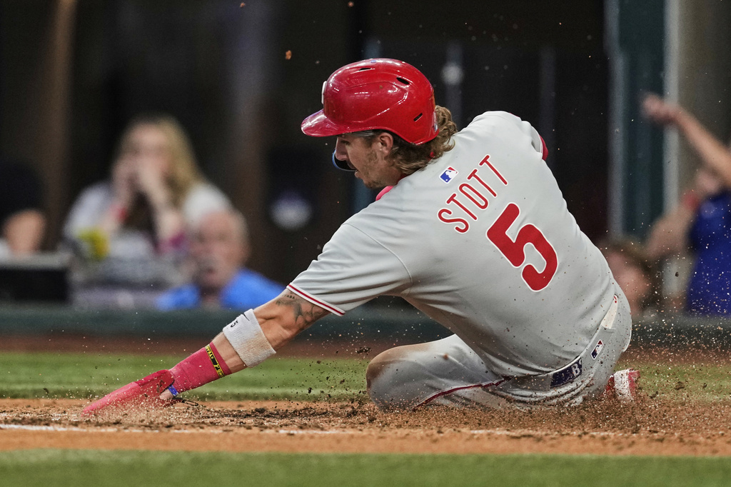 Philadelphia Phillies' Bryson Stott scores on a Weston Wilson single in the fifth inning of a baseball game against the Texas Rangers, Sunday, Aug. 10, 2025, in Arlington, Texas. (AP Photo/Tony Gutierrez)