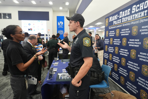 Ioan Barsan a recruiter with the Miami Dade School Police Dept. talks to a a job seeker during a job fair Wednesday, Oct. 1, 2025, in Miami. (AP Photo/Marta Lavandier) Ioan Barsan a recruiter with the Miami Dade School Police Dept. talks to a a job seeker during a job fair Wednesday, Oct. 1, 2025, in Miami. (AP Photo/Marta Lavandier)